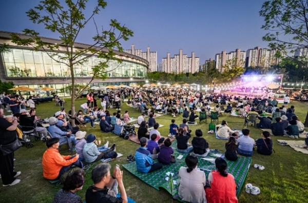 ▲ 수원시민들이 지난 5월 28일 수원 일월수목원 잔디광장에서 개관 1주년 기념으로 개최된 ‘별 헤는 가든 음악회’를 즐기고 있다.