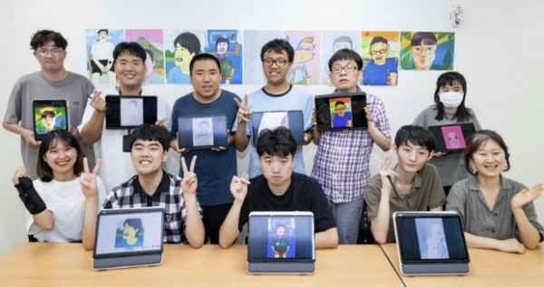▲ 수원시 고향사랑기금 활용 사업으로 진행 중인 호매실장애인종합복지관 디지털 드로잉 작가 양성 교육 참여자 등 관계자들이 작품이 담긴 태블릿을 들고 기념촬영을 하고 있다.